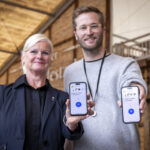 Ein Mann und eine Frau recken ihre Handys der Kamera entgegen.