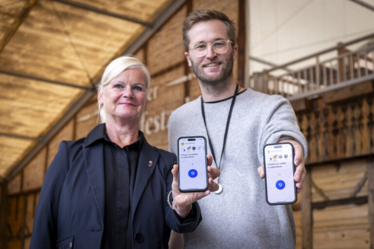 Ein Mann und eine Frau recken ihre Handys der Kamera entgegen.