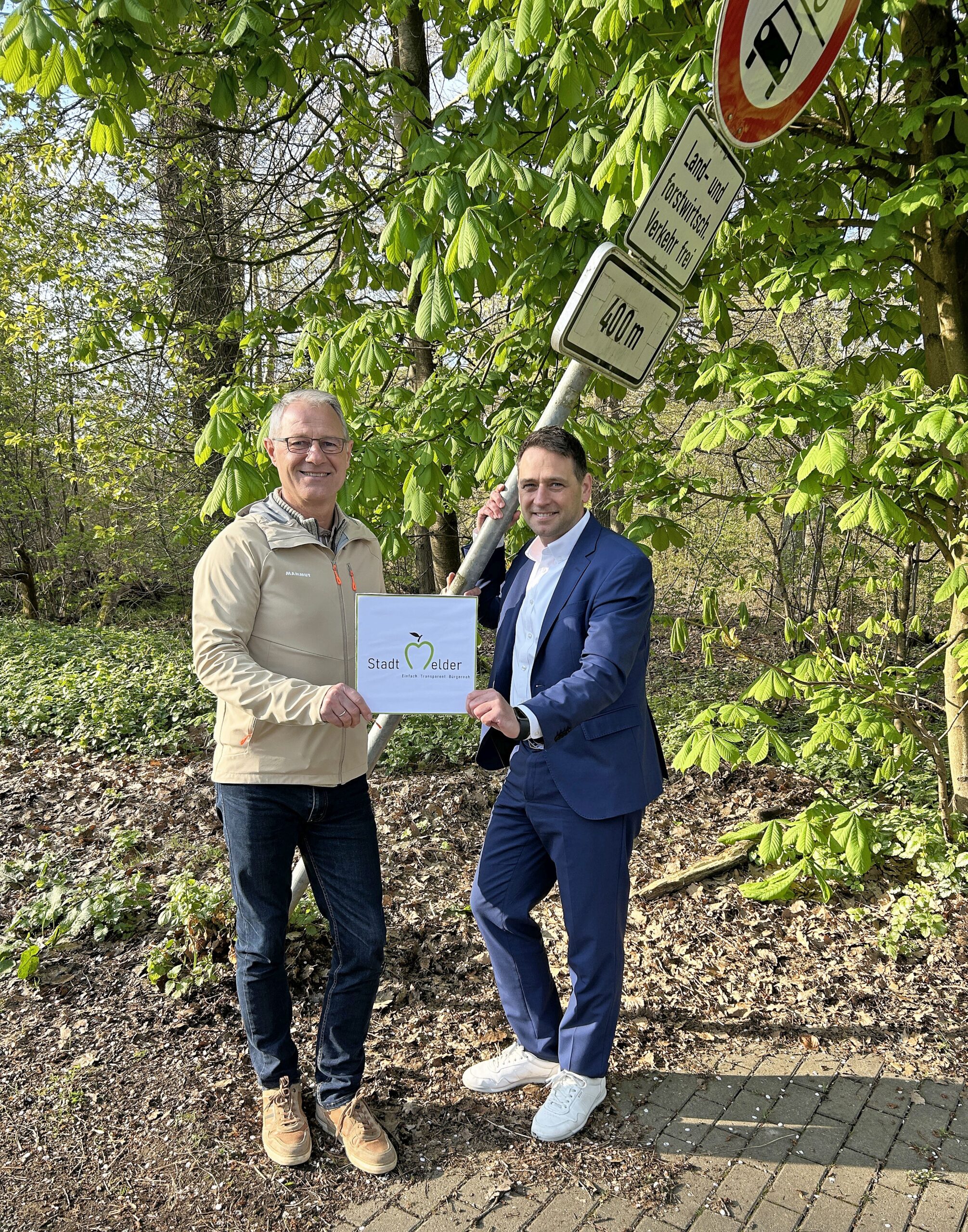 zwei Personen vor einem verbogenen Verkehrsschild