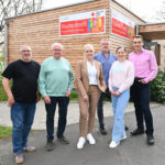 Mehrere Personen stehen vor einem Stadtteiltreff in Kassel Wolfsanger