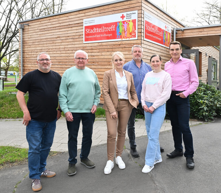 Mehrere Personen stehen vor einem Stadtteiltreff in Kassel Wolfsanger