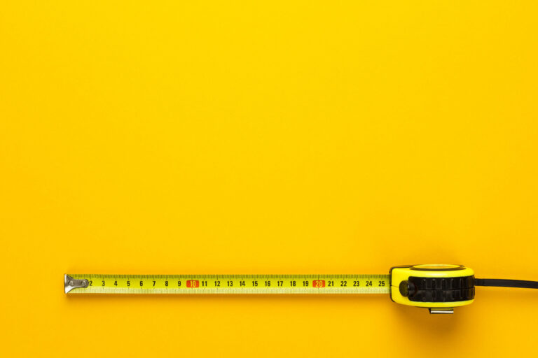 Gelbes Maßband auf gelbem Hintergrund.