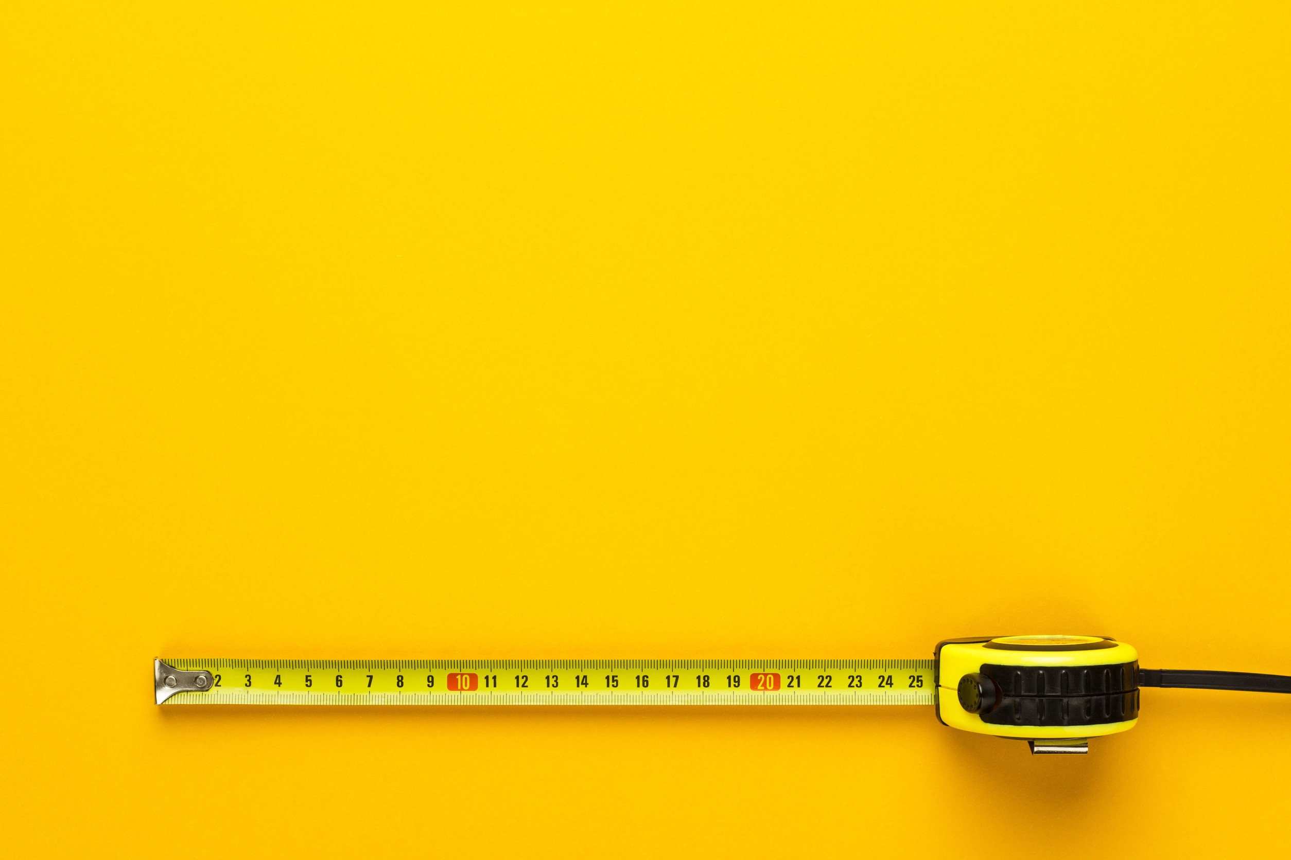 Gelbes Maßband auf gelbem Hintergrund.