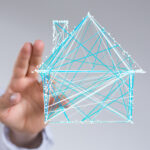 Eine Hand vor einem stilisierten Haus