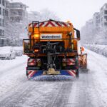 Räumfahrzeug auf einer verschneiten Straße in einer Stadt