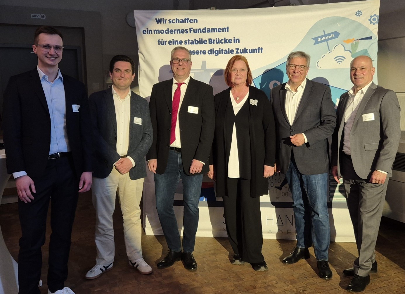 mehrere Personen stehen vor einer Leinwand mit einer Präsentation des Projekts SAP4HANA Wiesbaden