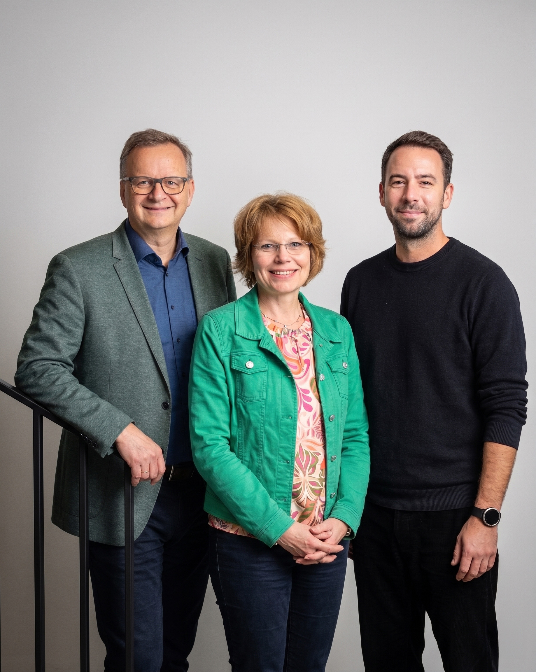drei Personen vor grauem Hintergrund