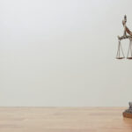 Justizia-Staue auf einem Tisch, heller Hintergrund