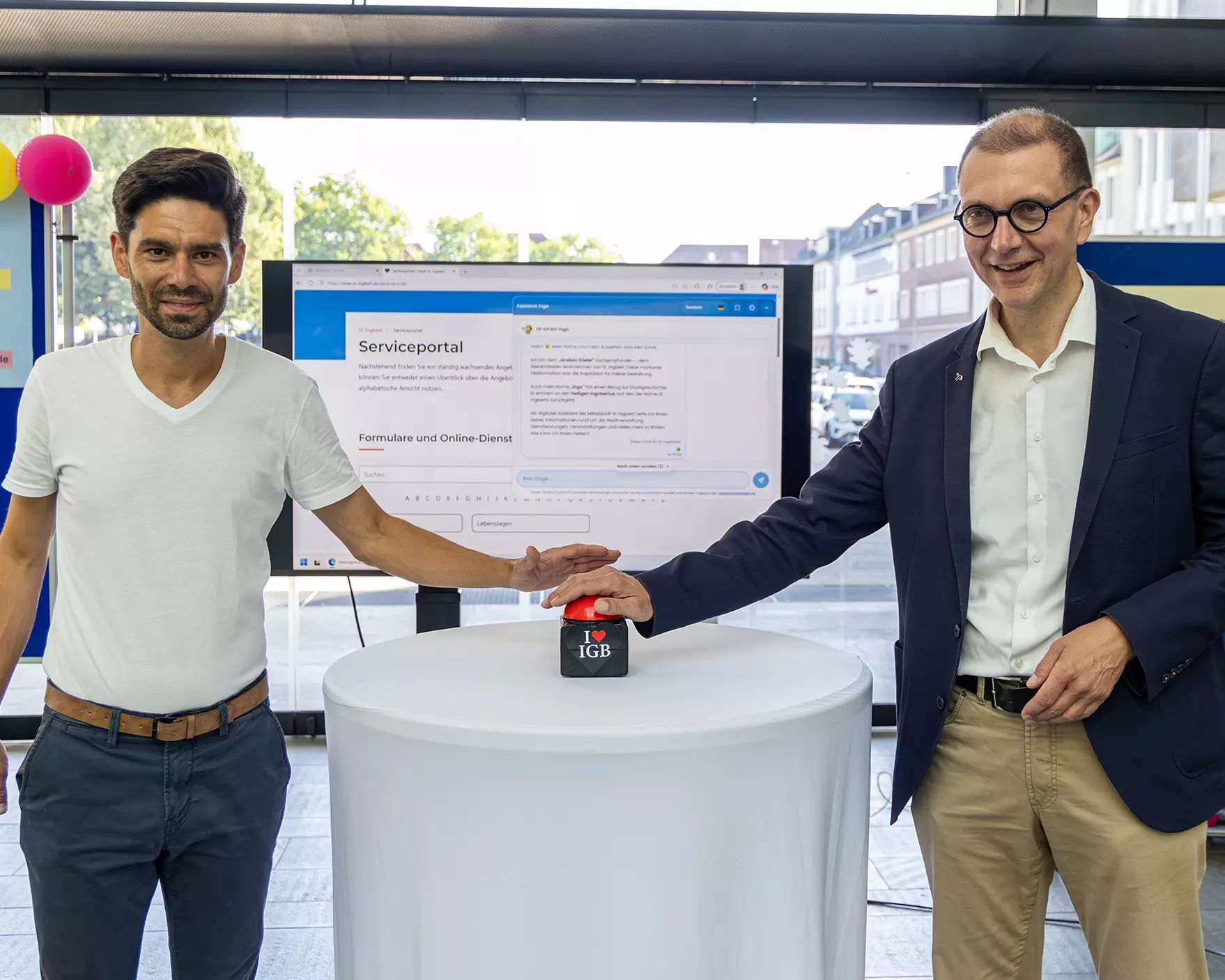 2 Männer vor Bildschirm, die einen Startknopf drücken_KI_Chatbot_INGO-gestartet