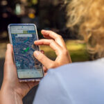 Blick über die Schulter einer Frau, die auf ihrem Smartphone die Coole Karte der Stadt Münster geöffnet hat