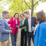 Mehrere Personen auf einem Gehweg, schauen auf ein Smartphone