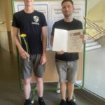 Zwei Personen halten eine Urkunde