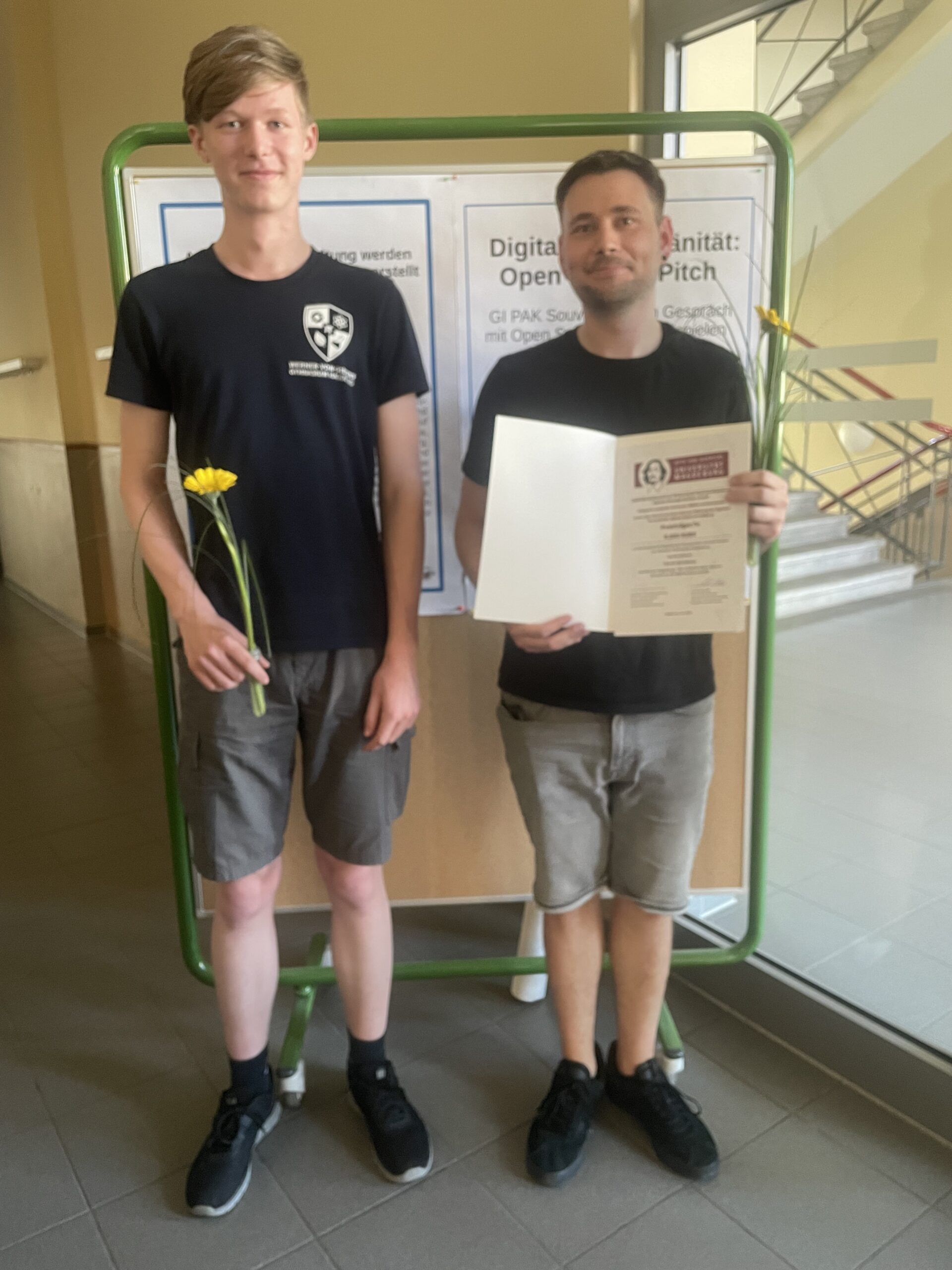 Zwei Personen halten eine Urkunde