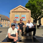 Vier Personen aus dem Bad Belziger Smart-City-Team sitzen vor einer Infotafel
