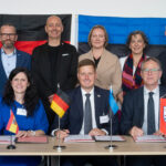 Gruppenfoto vor deutscher und estnischer Flagge.