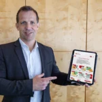 Der Mainzer Oberbürgermeister Nino Haase zeigt auf ein iPad, das die neue Microsite Bürgerbeteiligung Mainz zeigt