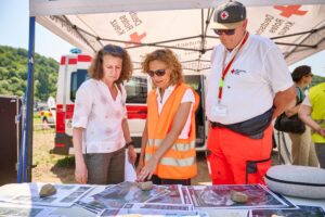 Cornelia Weigand, Landrätin des Kreises Ahrweiler (links), gehörte zu den Gästen der Übung. Hier informiert sich die Landrätin über die gedruckten Karten mit Lagebild-Informationen. Konstanze Lechner von der DLR-Projektleitung für RESITEK erläutert die Abbildungen.