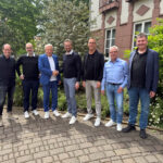 sieben Männer stehen nebeneinander_ekom21 wird Mitglied des VOIS-Vereins