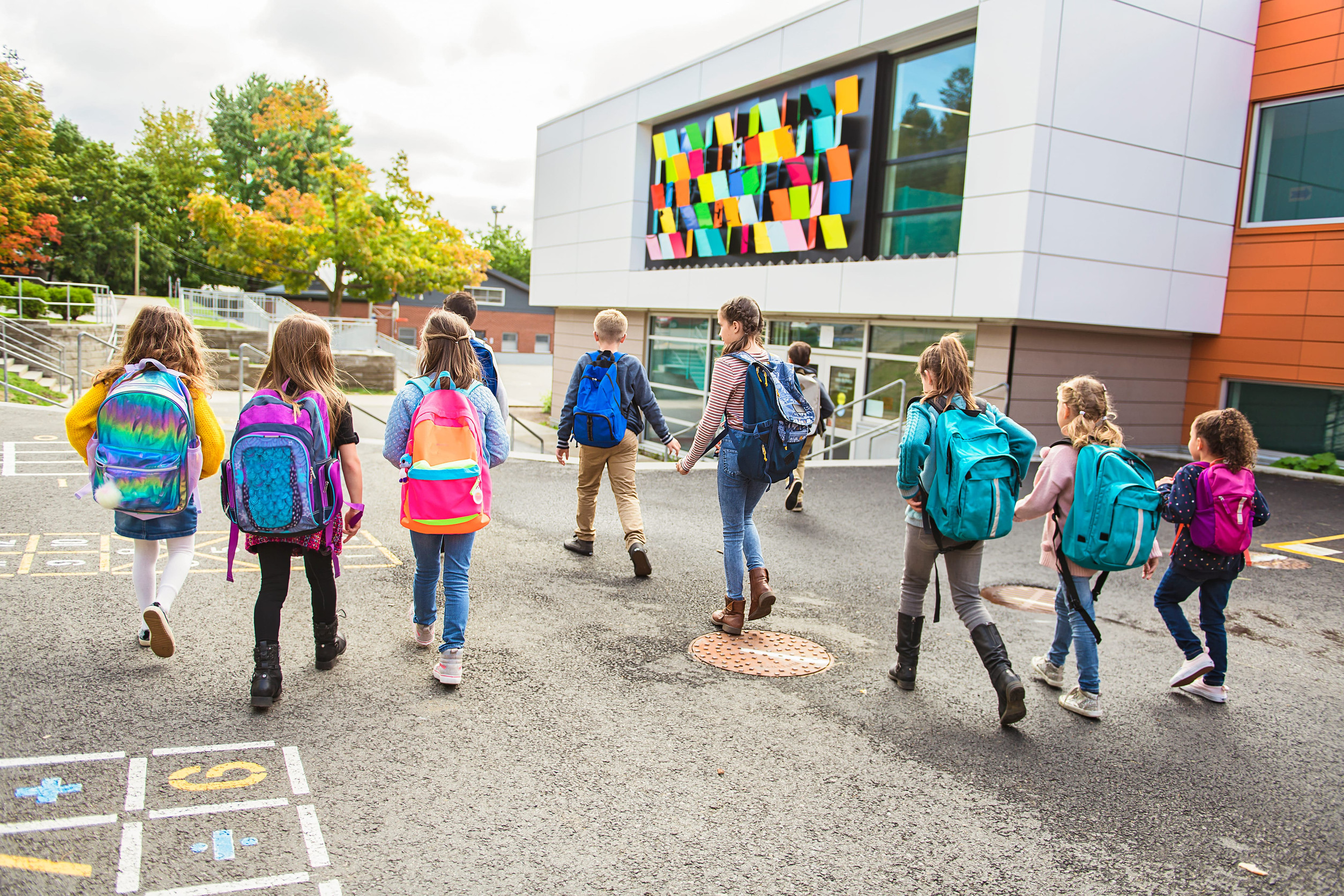 Eine Gruppe von Kindern mit Schulranzen auf dem Weg zur Schule