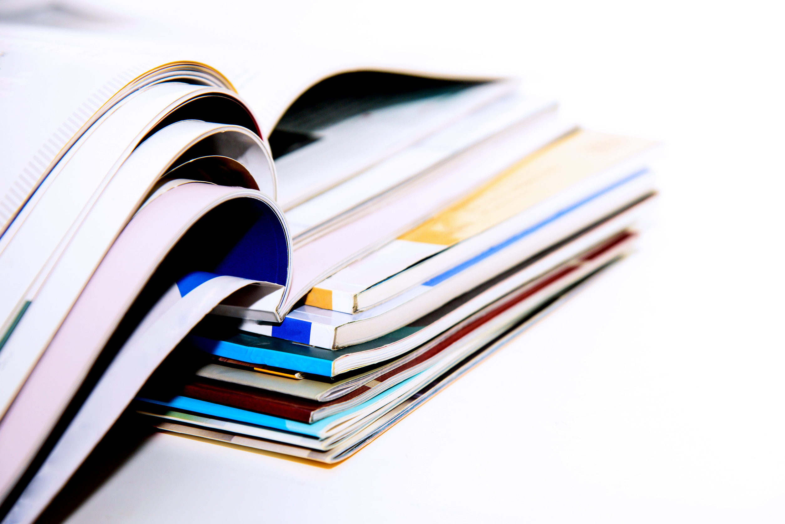 Stapel von broschierten Printprodukten, Titel nicht erkennbar, teilweise aufgeschlagen