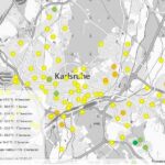 Kartenansicht in Grau mit gelben, grünen und orangenen Punkten.