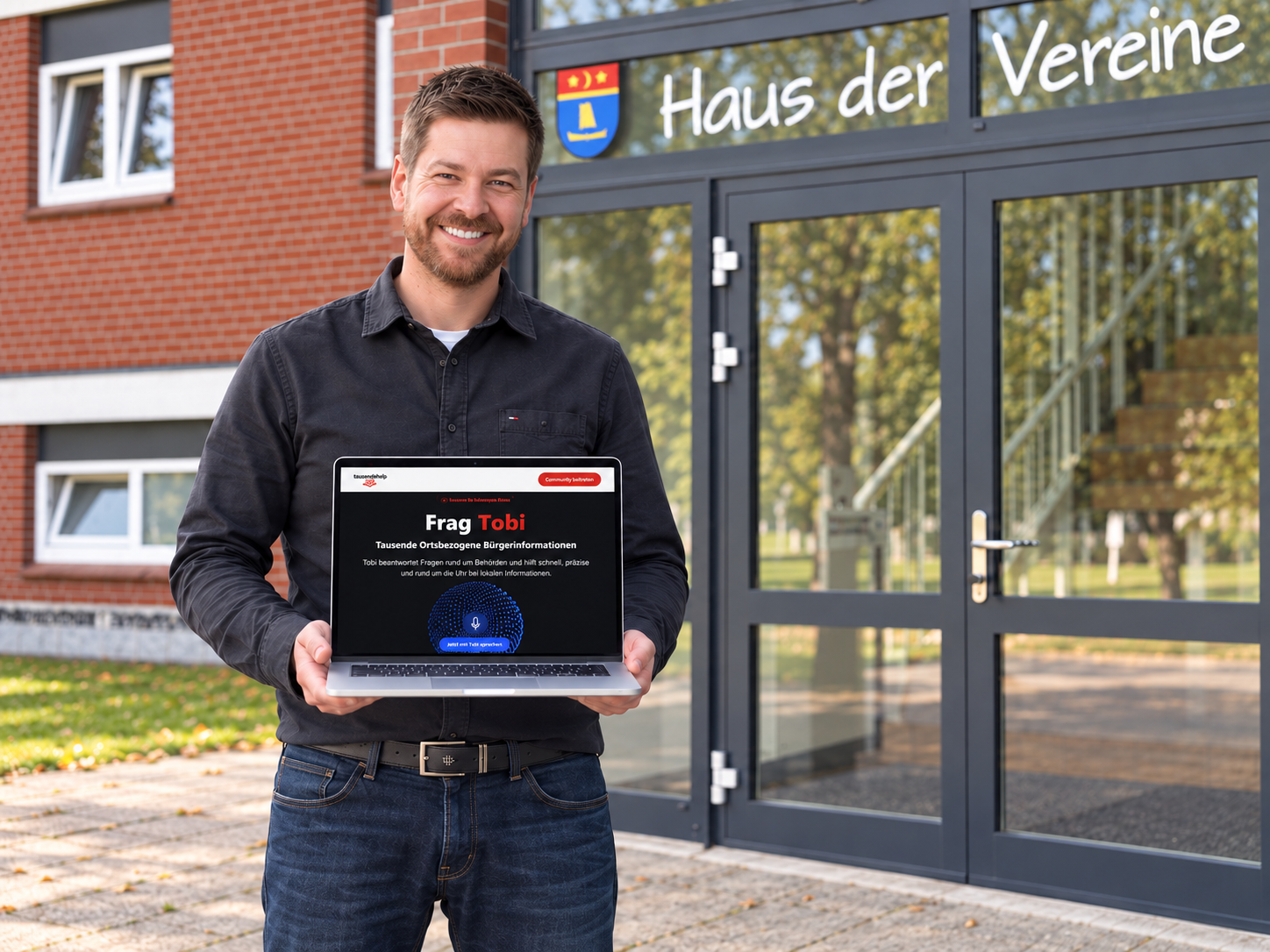 Martin Dellwing steht mit einem Laptop vor dem Haus der Vereine.