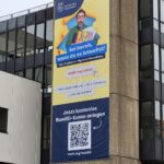 Infobanner zu Onlinediensten am Aufzugturm des Rathauses in Rheydt.