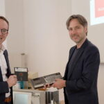 Zwei Personen halten eine 5¼-Diskette zur Datensicherung in die kamera