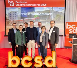 Personengruppe zum Gruppenbild aufgestellt hinter den Buchstaben "bcsd"