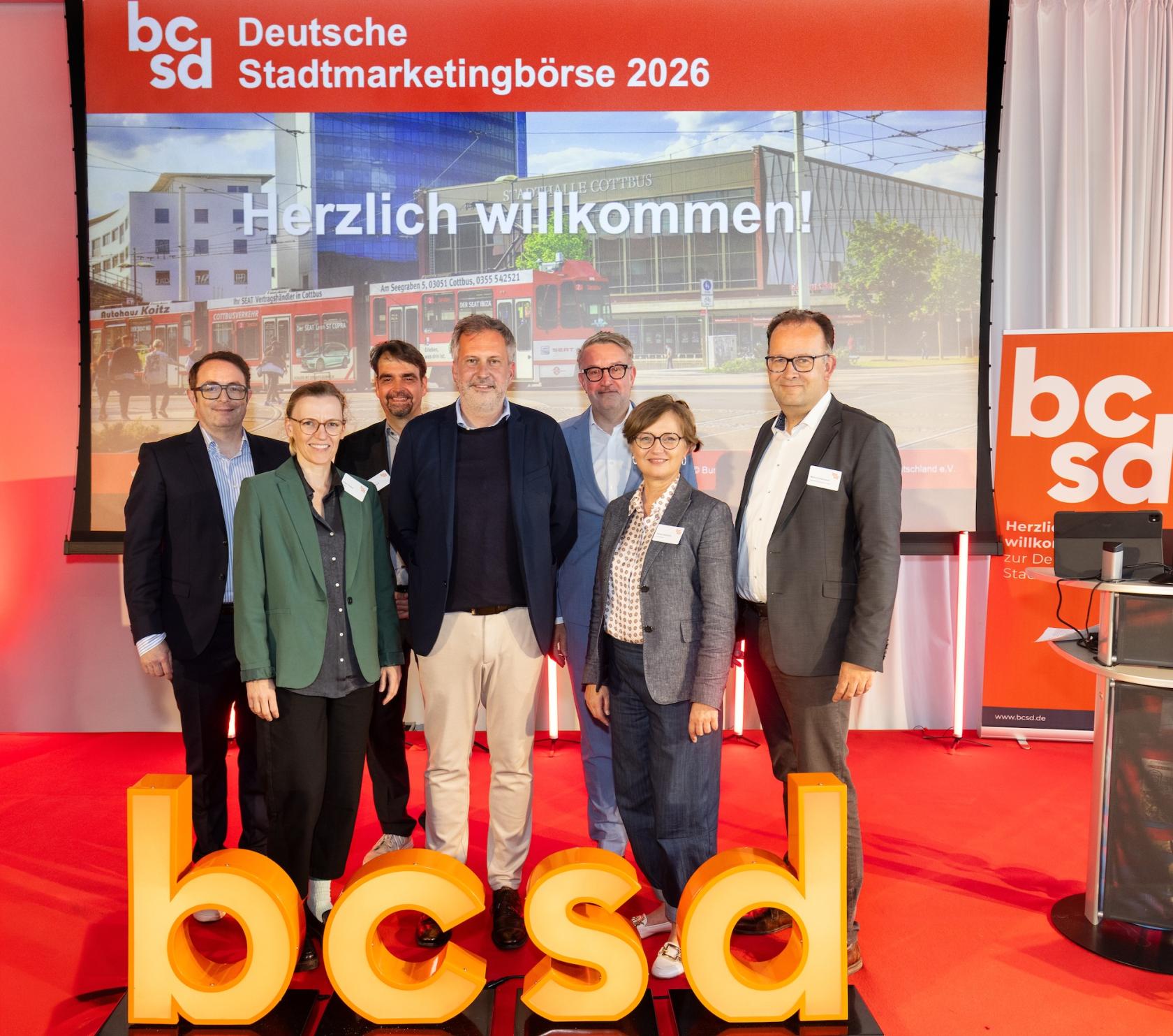 Personengruppe zum Gruppenbild aufgestellt hinter den Buchstaben "bcsd"