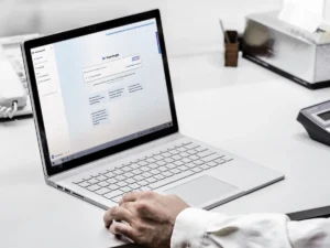 Ein laptop steht aufgeklappt auf einem Schreibtisch, auf dem Monitor ist die Anwendung KAI zu sehen