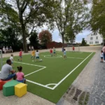 auf einem kleinen Fußballfeld an einem öffentlichen Platz spielen Kinder