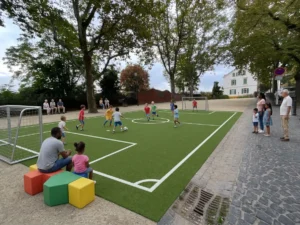 auf einem kleinen Fußballfeld an einem öffentlichen Platz spielen Kinder