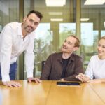 Eine Gruppe von Businesspersonen sitzen an einem Tisch und besprechen sich