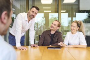 Eine Gruppe von Businesspersonen sitzen an einem Tisch und besprechen sich