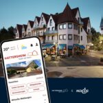 Hattersheim-App auf einem Smartphone vor einem Gebäude