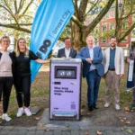 Zwei Frauen und vier Männer stehen neben einem der neuen smarten Mülleimer in Dortmund.